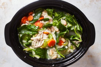 slow cooker filled with tuscan soup ingredients
