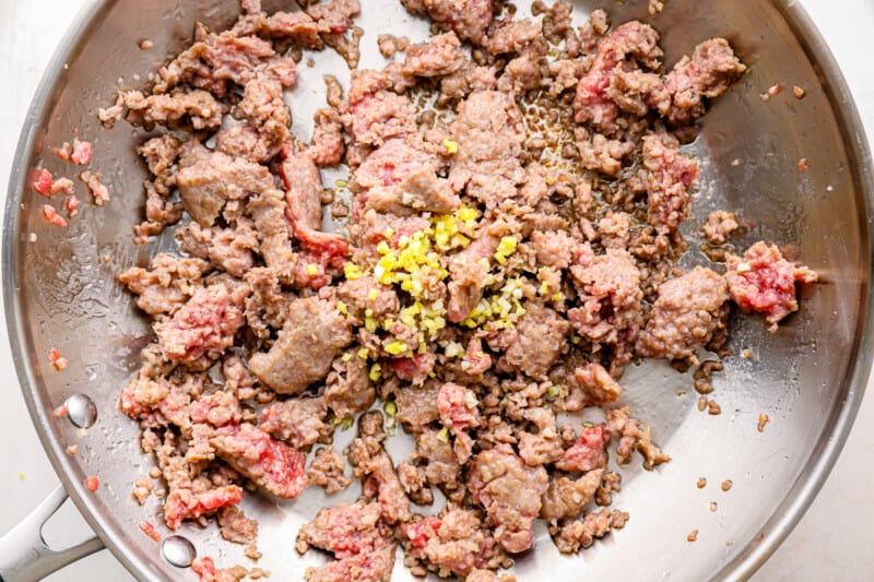 pork in a frying pan with garlic and ginger.