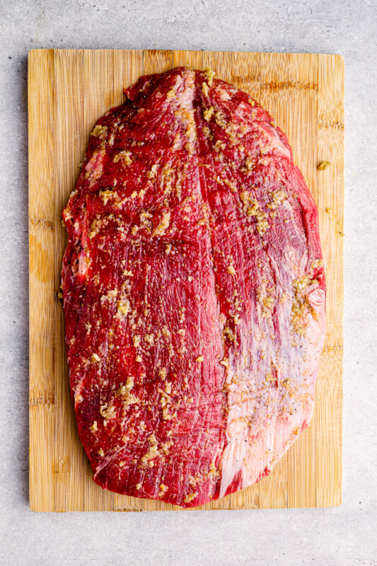 raw flank steak on a cutting board