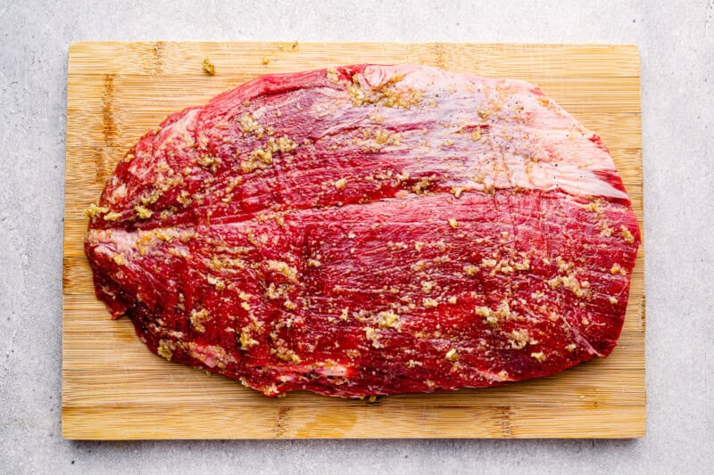 raw flank steak on a cutting board