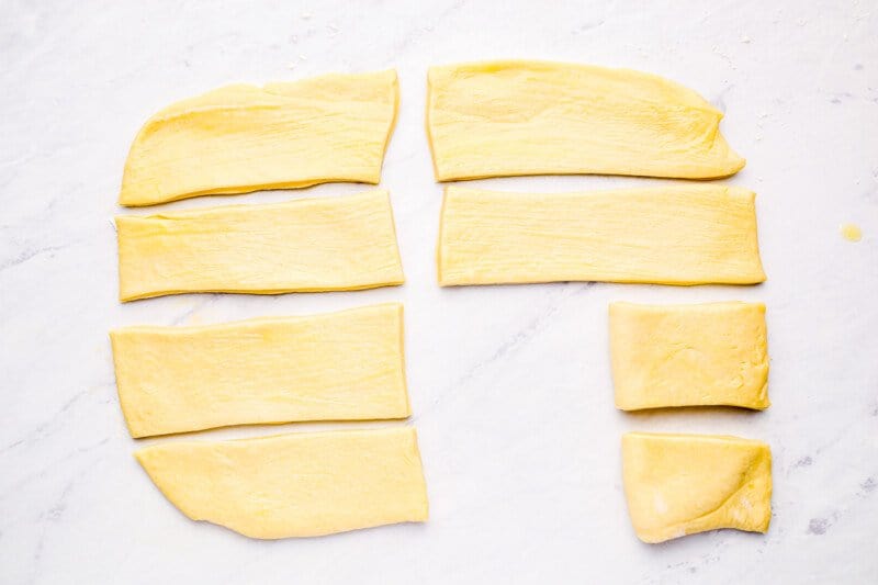 parker house roll dough strips being folded in half.