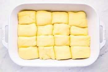 proofed parker house rolls in a baking pan.