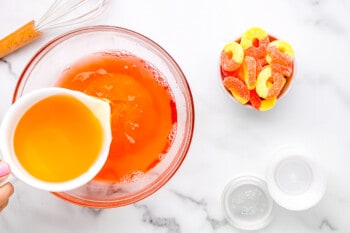 whiskey added to unset peach jello in a glass bowl.