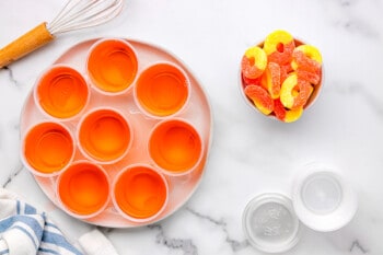 8 peach jello shots on a tray.