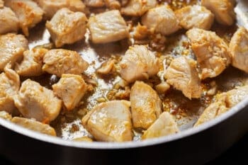 small pieces of chicken cooking in a skillet