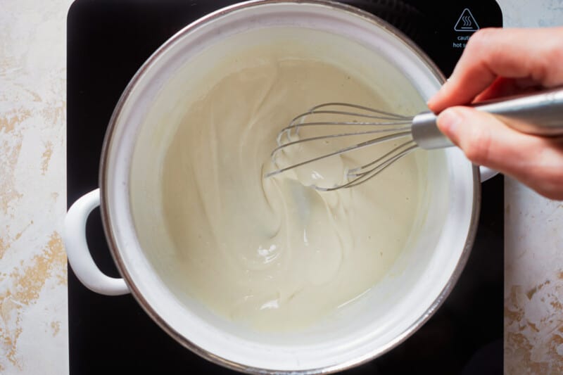 whisking milk and flour together on the stove