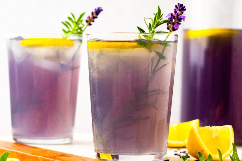 two glasses of lavender lemonade with lavender and lemons as garnish