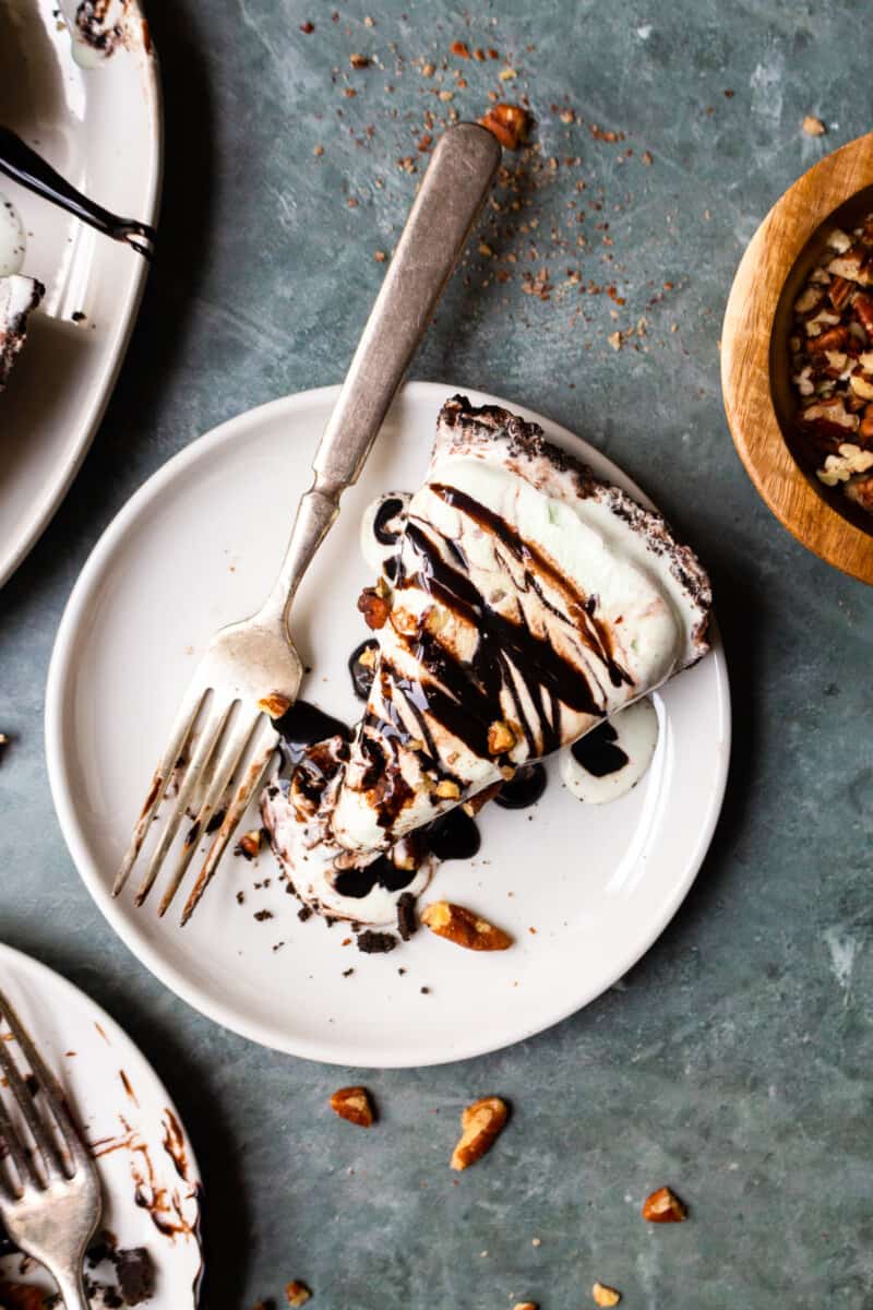 white plate with a slice of mint chocolate ice cream pie