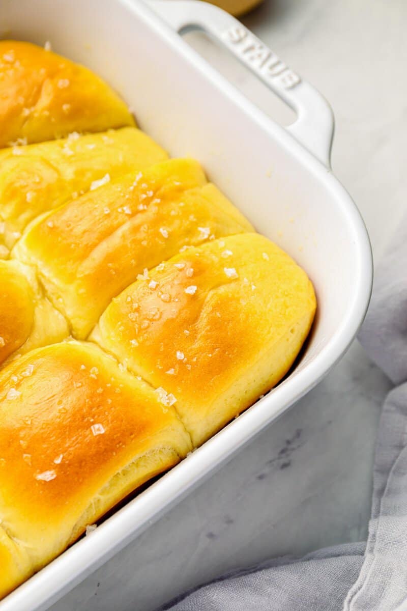 close up of parker house rolls in a white baking pan.