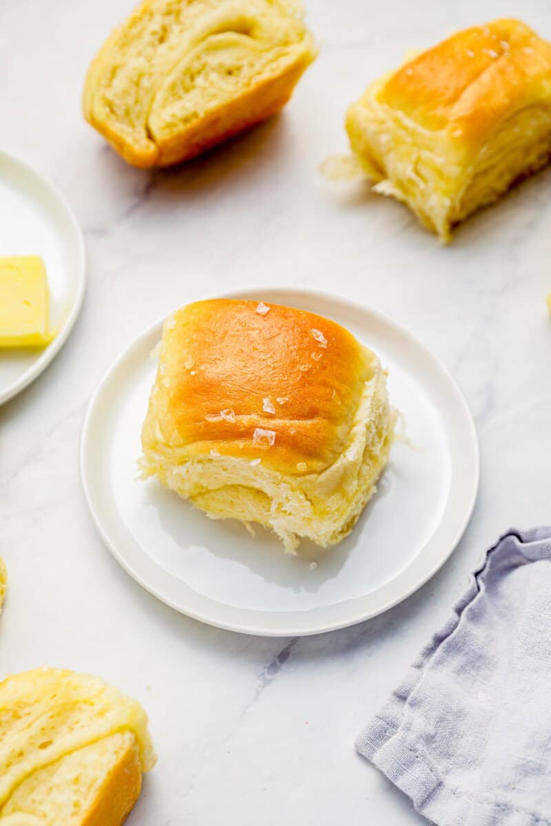 a parker house roll on a white plate.