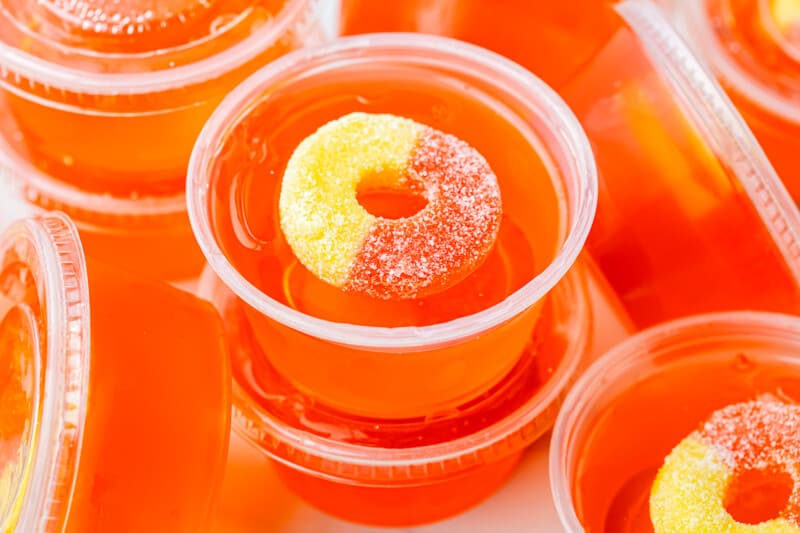 stacked peach jello shots with peach rings.