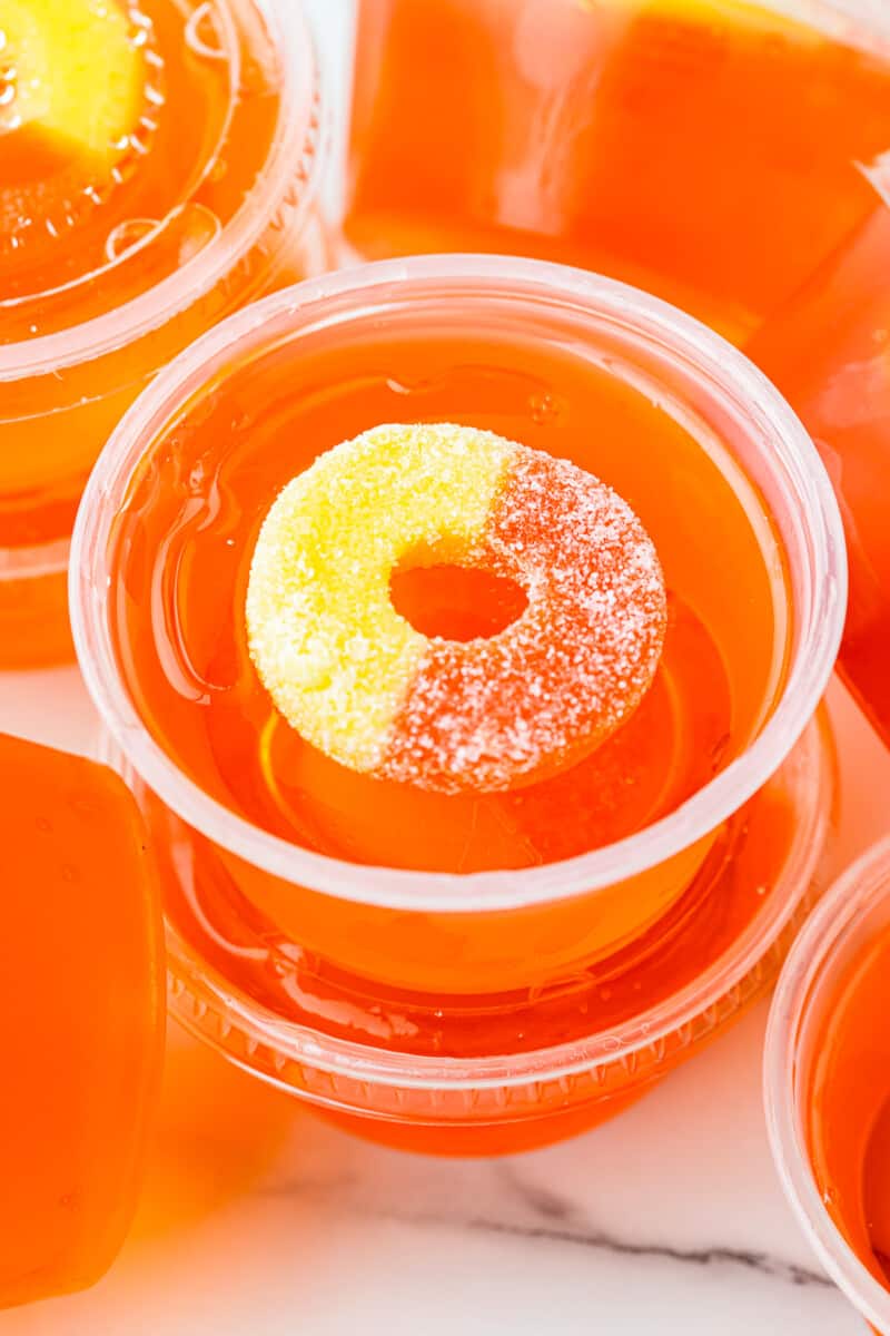 stacked peach jello shots with peach rings.