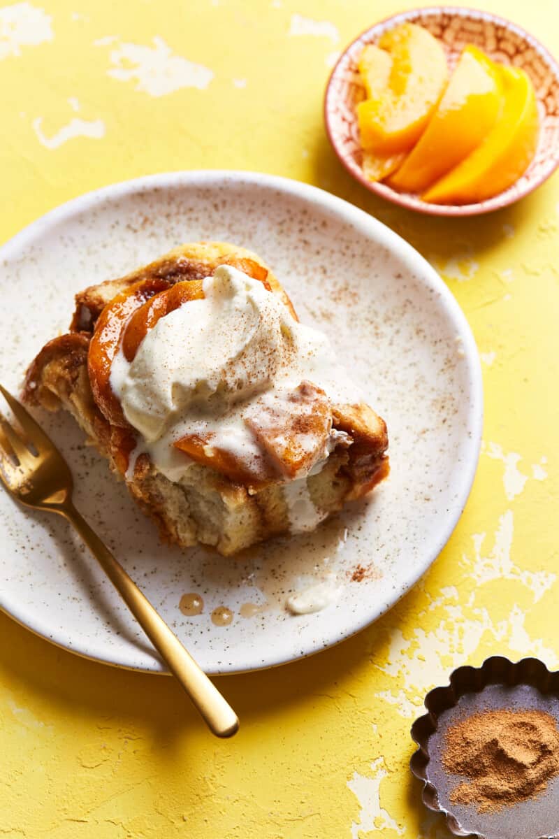 overnight french toast on a plate with peaches and cream