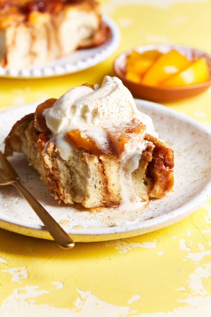 overnight french toast on a plate topped with peaches and cream