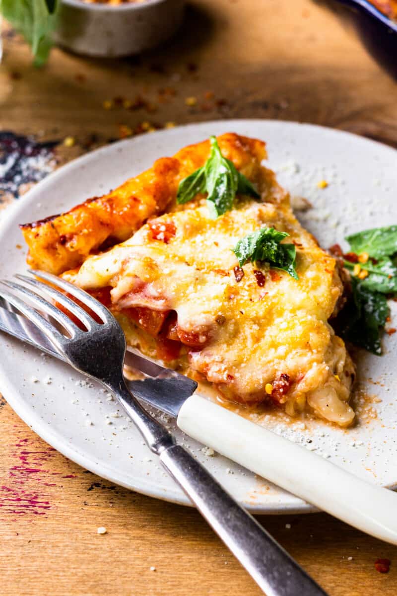 a slice of skillet pizza on a plate with a fork and knife