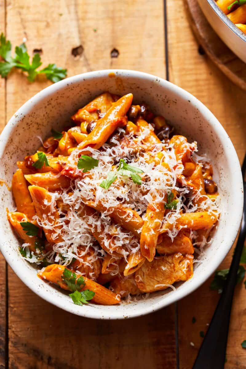 bowl of chicken alfredo penne pasta topped with cheese