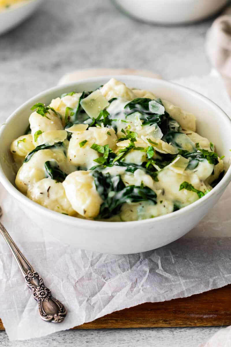 parmesan spinach gnocchi in a white bowl.