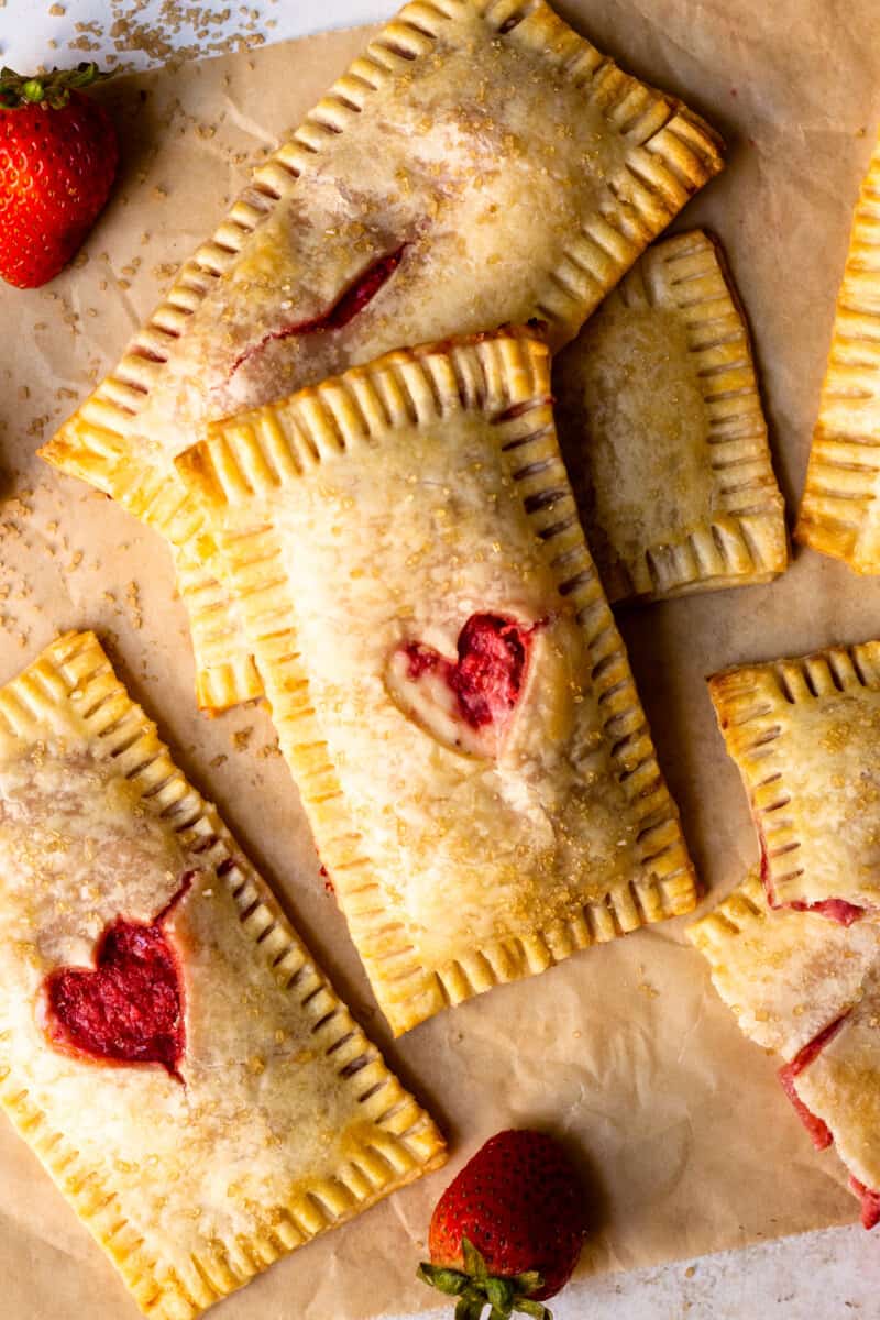 hand pies with heart shapes cut out of the front, piled together on parchment paper