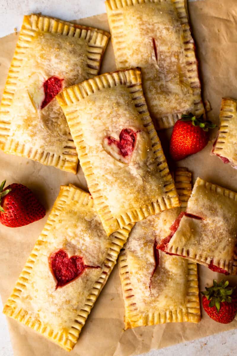 strawberry and cream cheese pies stacked on parchment paper