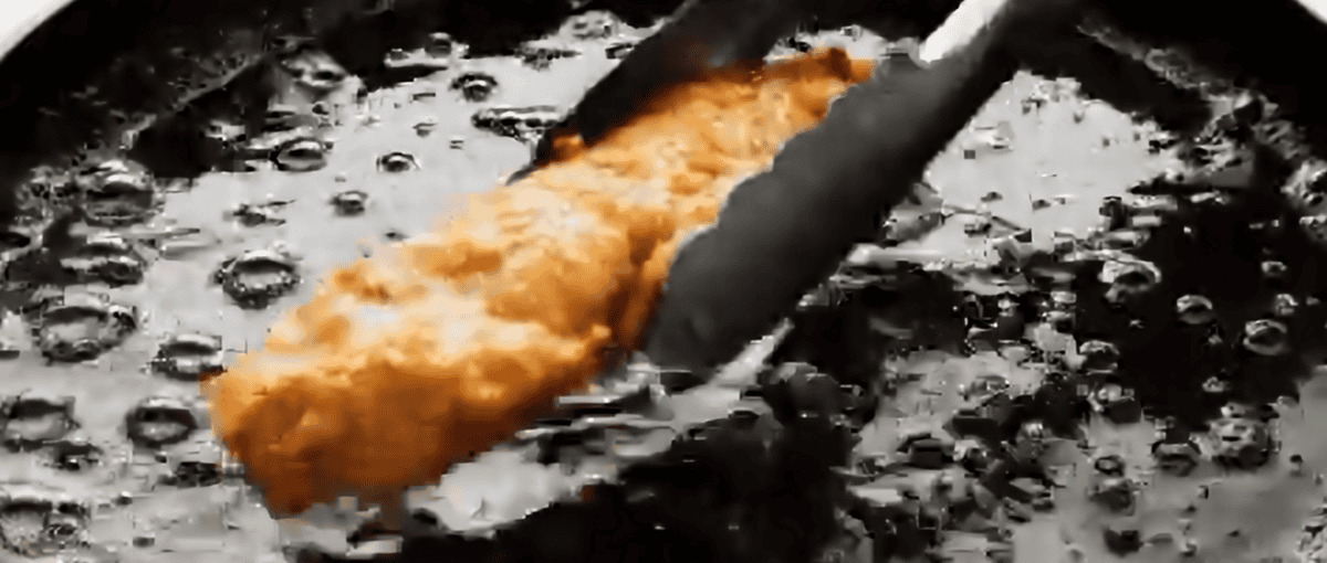 Chicken strip cooking in oil. 