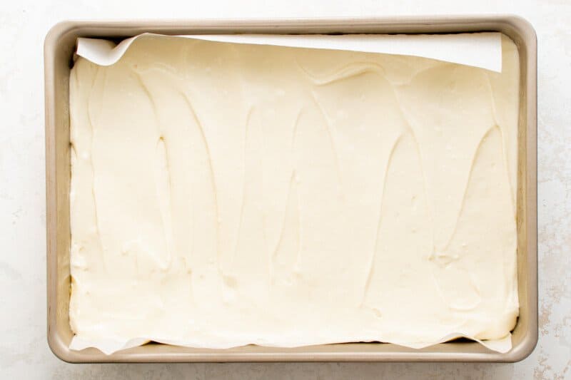 a layer of cheesecake mix smoothed into a baking pan