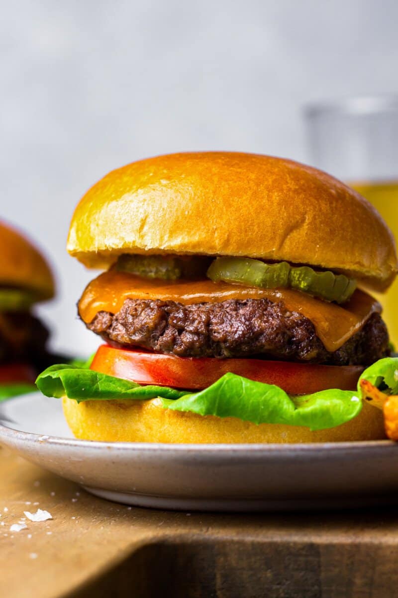 hamburger with lettuce, tomato, cheese, and pickles