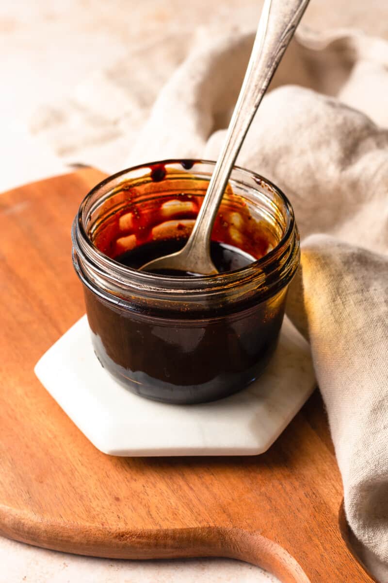 jar of balsamic vinegar reduction with a spoon dipped in it