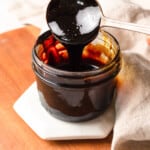 dipping a spoon into a jar of balsamic glaze