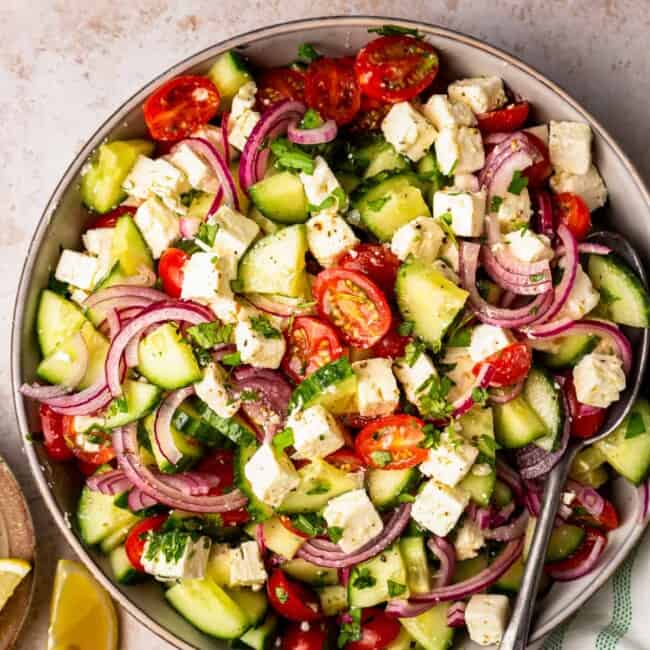 large bowl filled with a colorful cucumber tomato salad