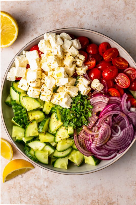 large bowl filled with ingredients for a cucumber tomato salad