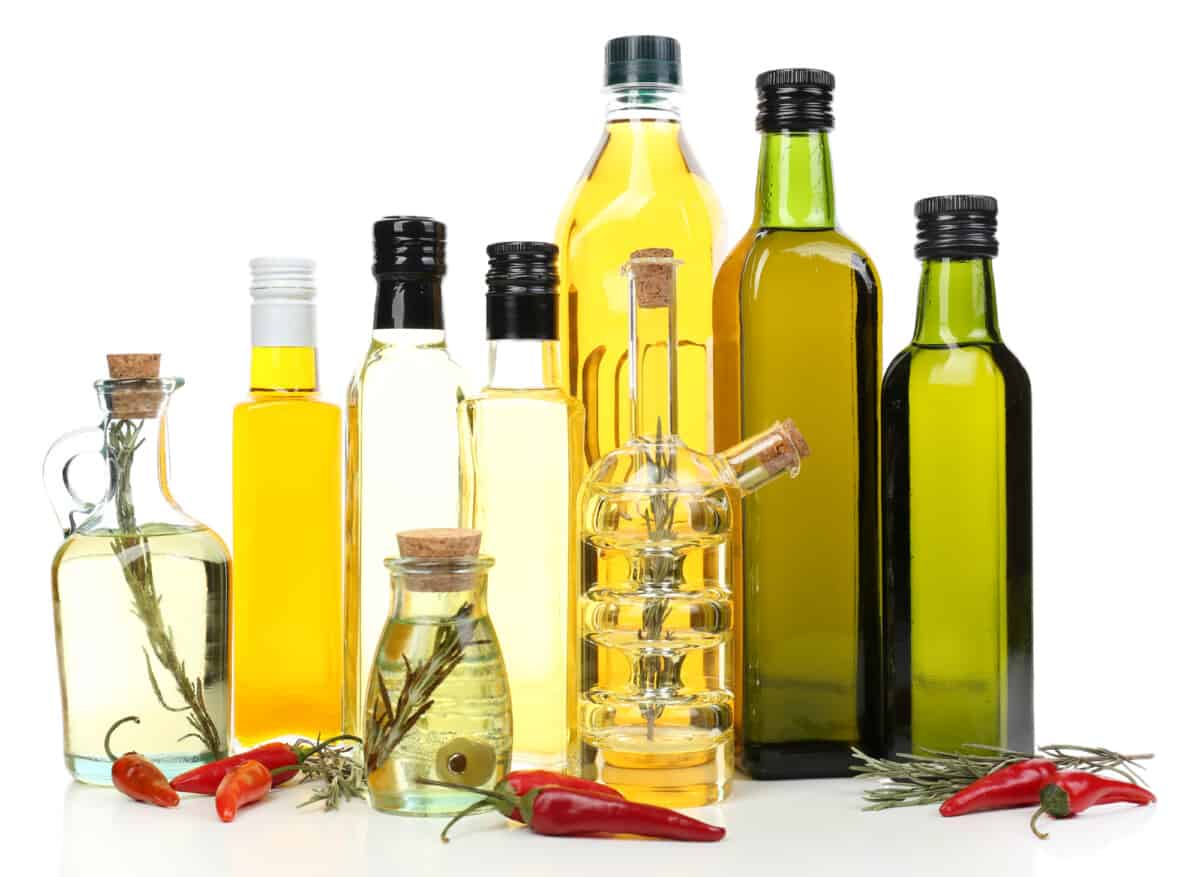 A group of bottles of olive oil and other other cooking oils.
