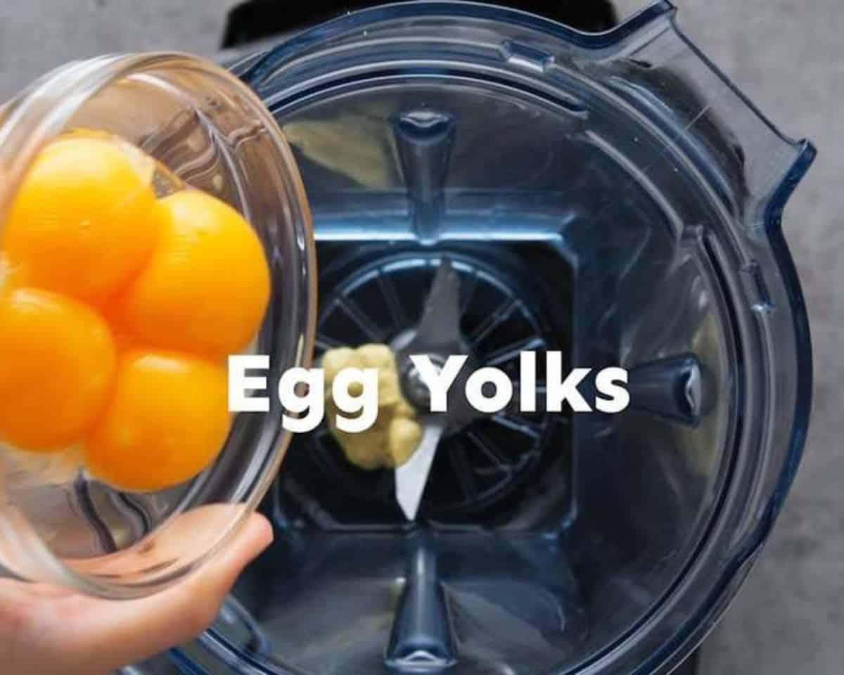 Pouring eggs into the blender to make the hollandaise sauce.