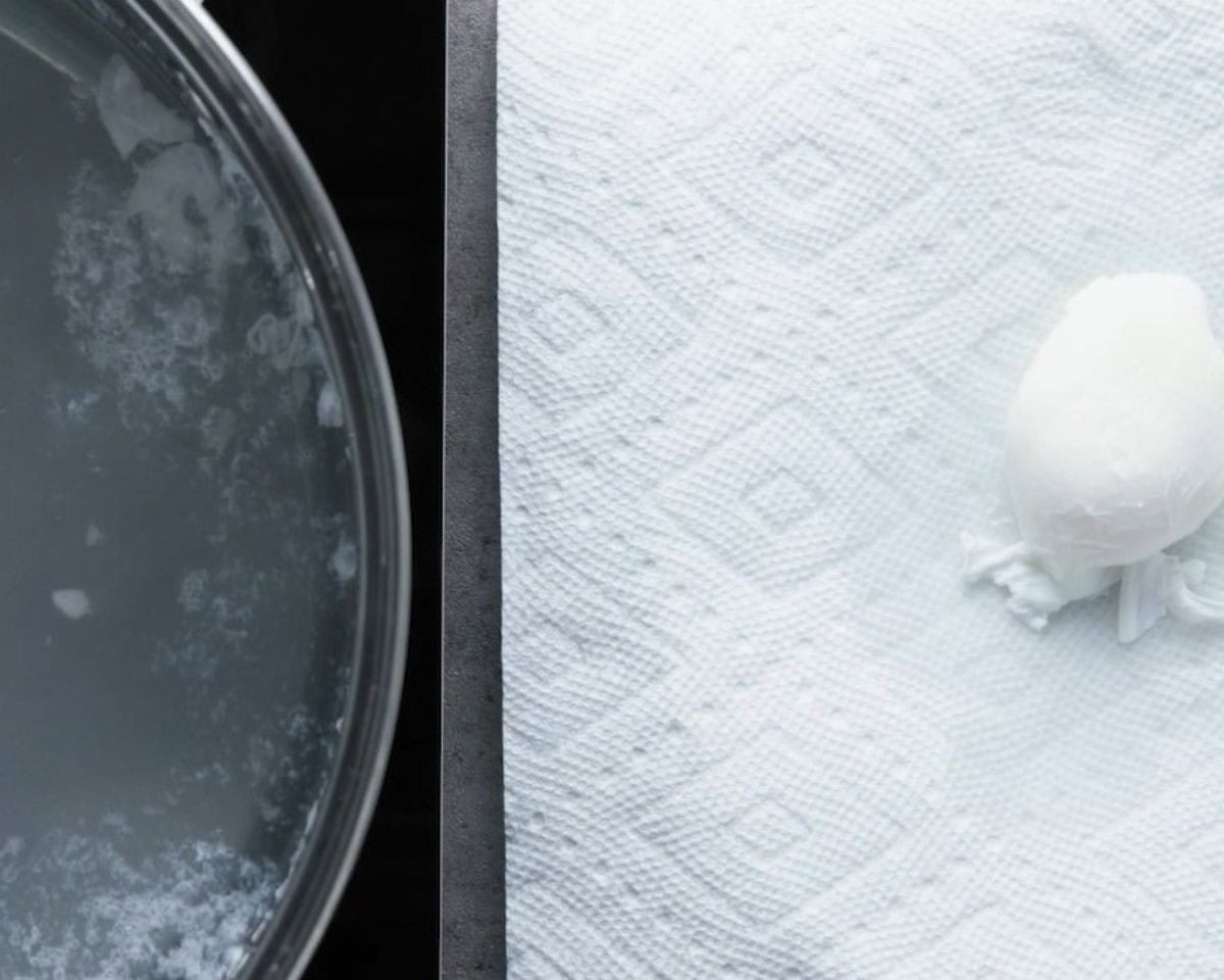 Transferring the poached eggs to a paper towel.