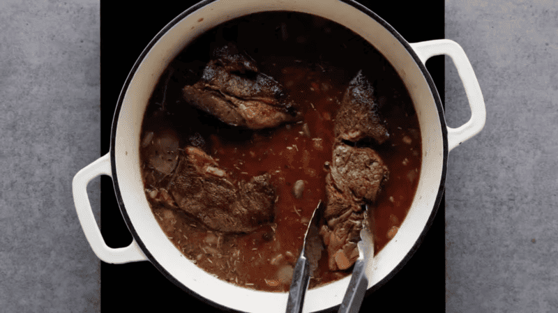 beef chuck roast in a pot with broth.
