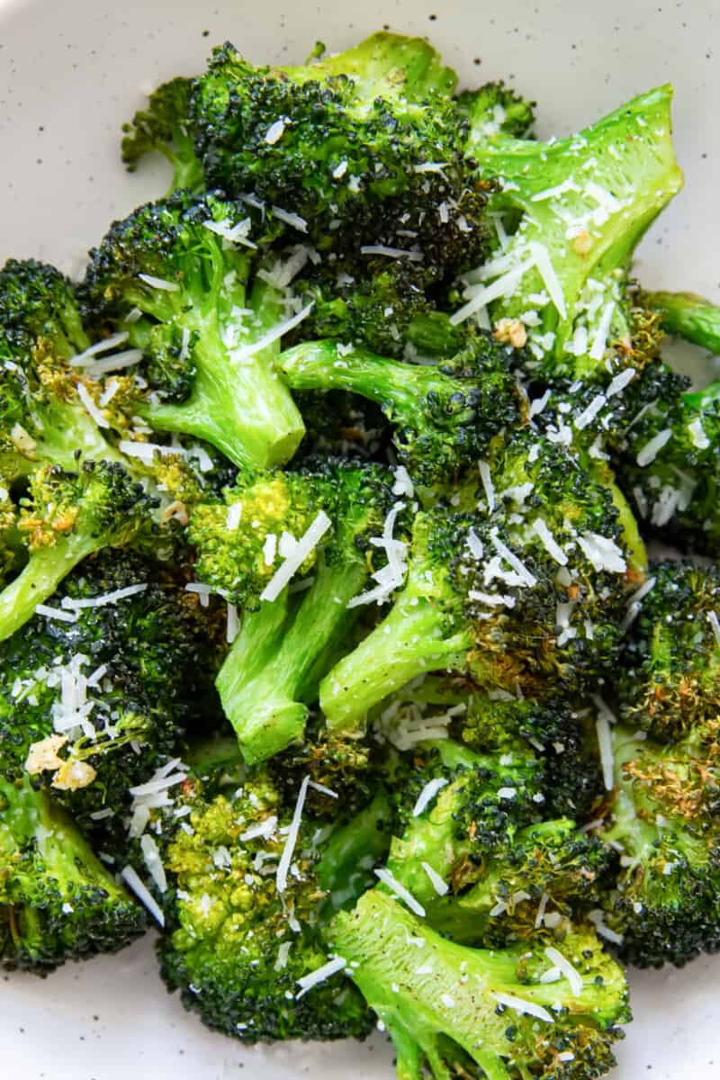 close up of air fryer broccoli in a white bowl.