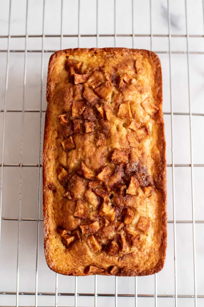 overhead view of a loaf of apple cinnamon bread on a cooling rack