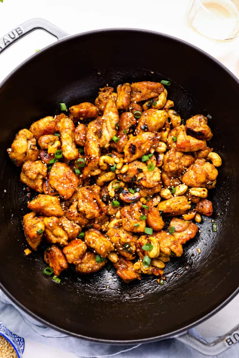 overhead view of cashew chicken in a cast iron wok.