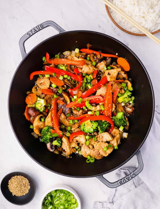 overhead view of chicken stir fry in a cast iron wok.