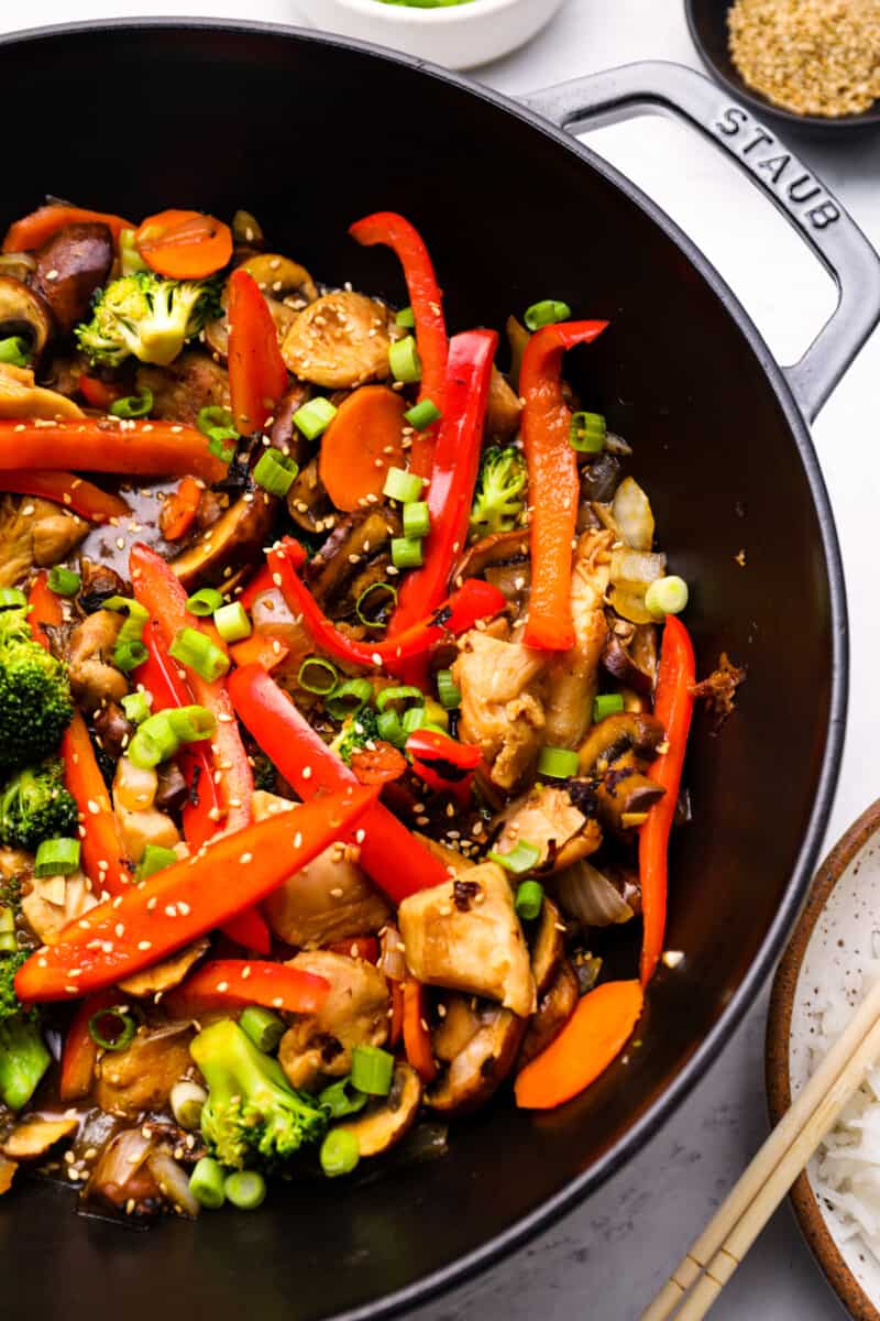 close up view of chicken stir fry in a cast iron wok.