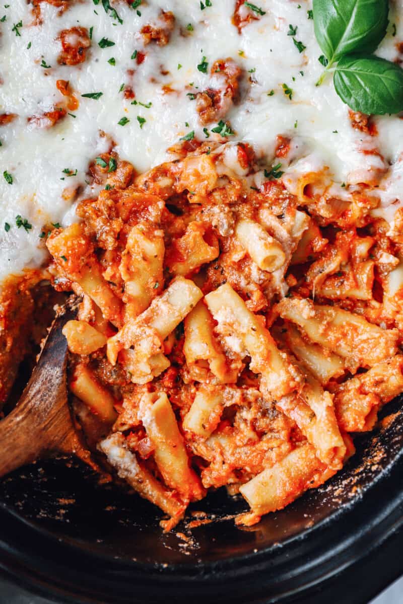 crockpot baked ziti in a crockpot with a wooden spoon.