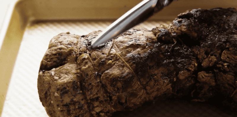 Cutting the strings on a beef tenderloin.