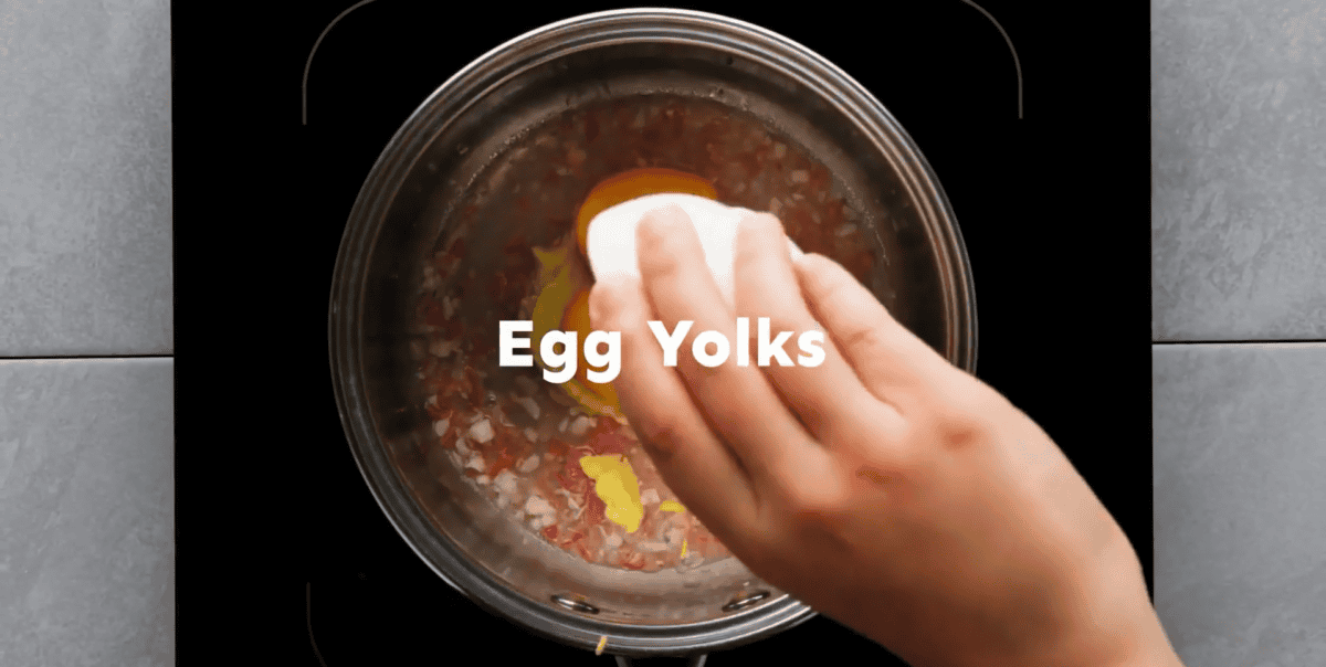Adding Dijon and egg yolks to the pot. 