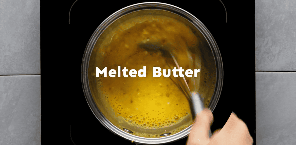 Adding melted butter to the mixture.