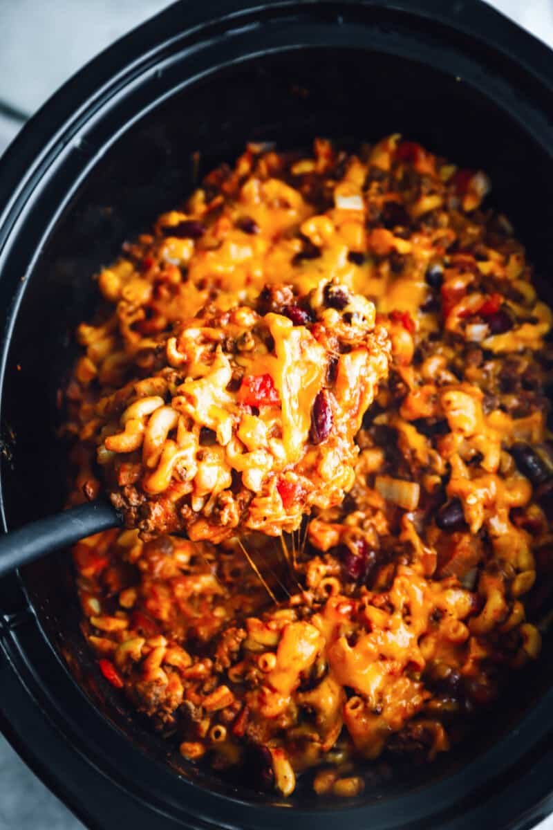 close up of crockpot chili mac in a crockpot with a spoon.