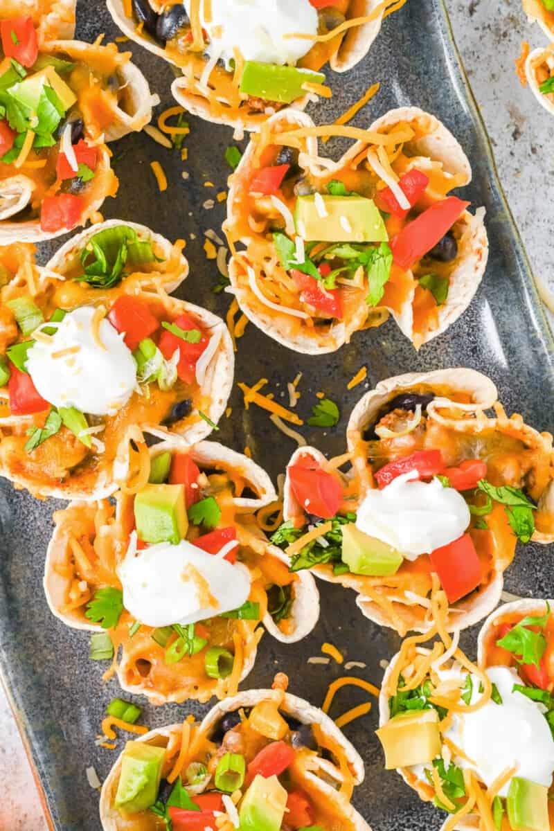 close up of 8 enchilada cups on a metal serving tray.