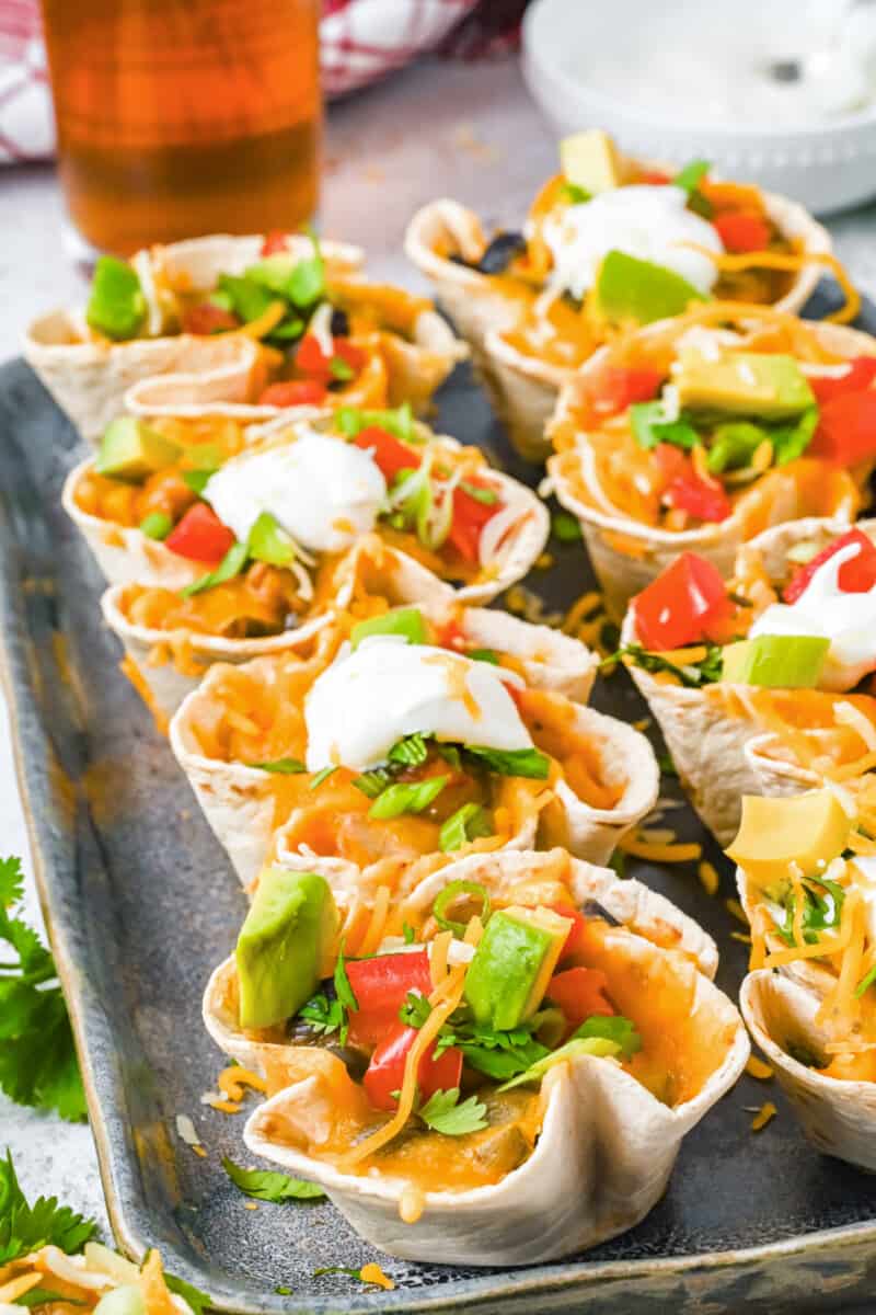 close up of 8 enchilada cups on a metal serving tray.