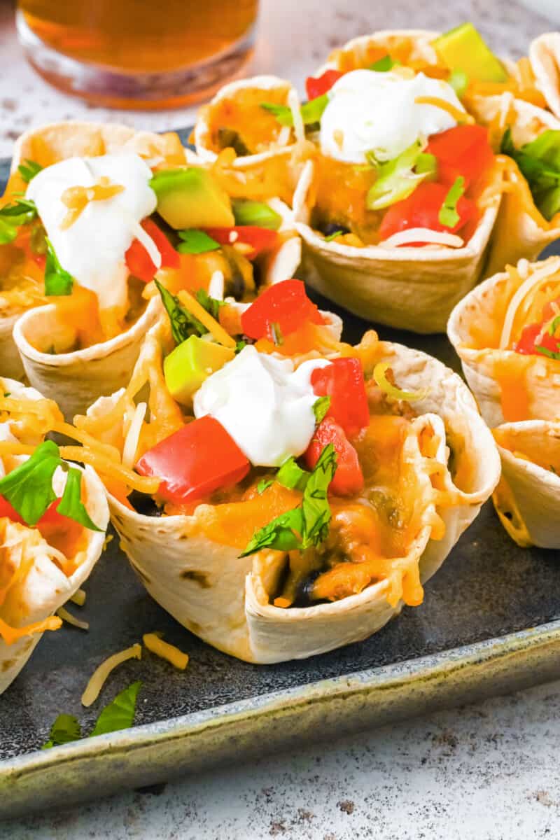 close up of enchilada cups on a metal serving tray.