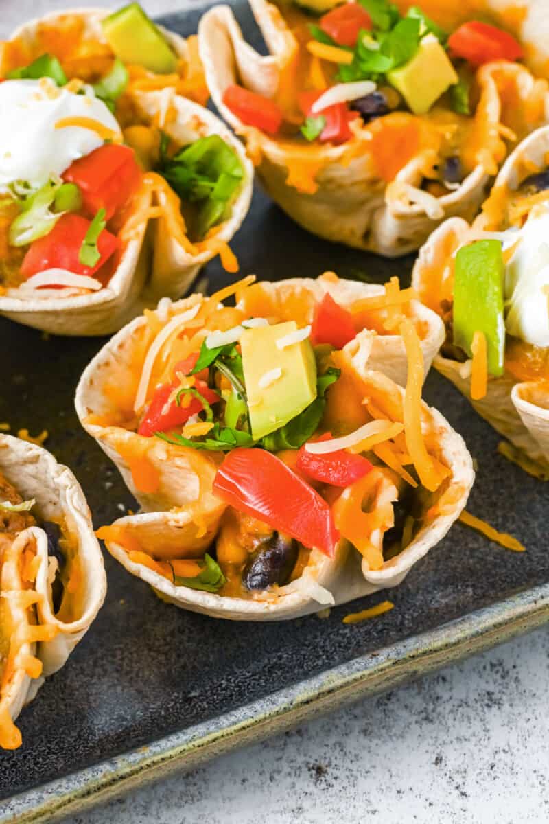 close up of enchilada cups on a metal serving tray.