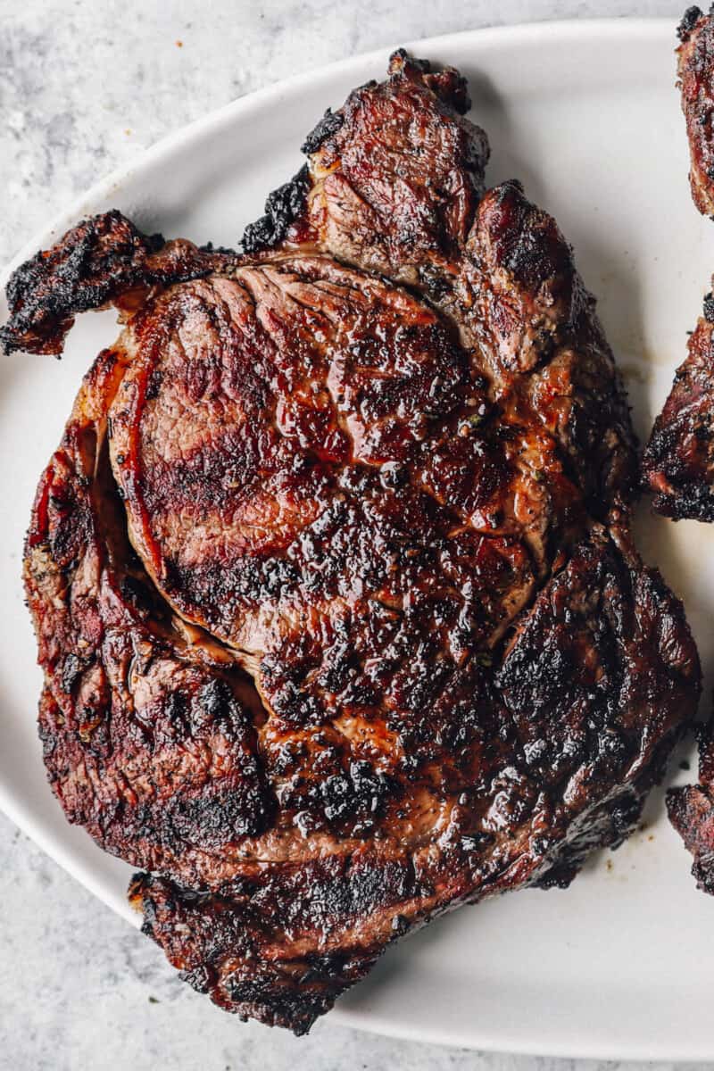 a grilled ribeye steak on a white plate