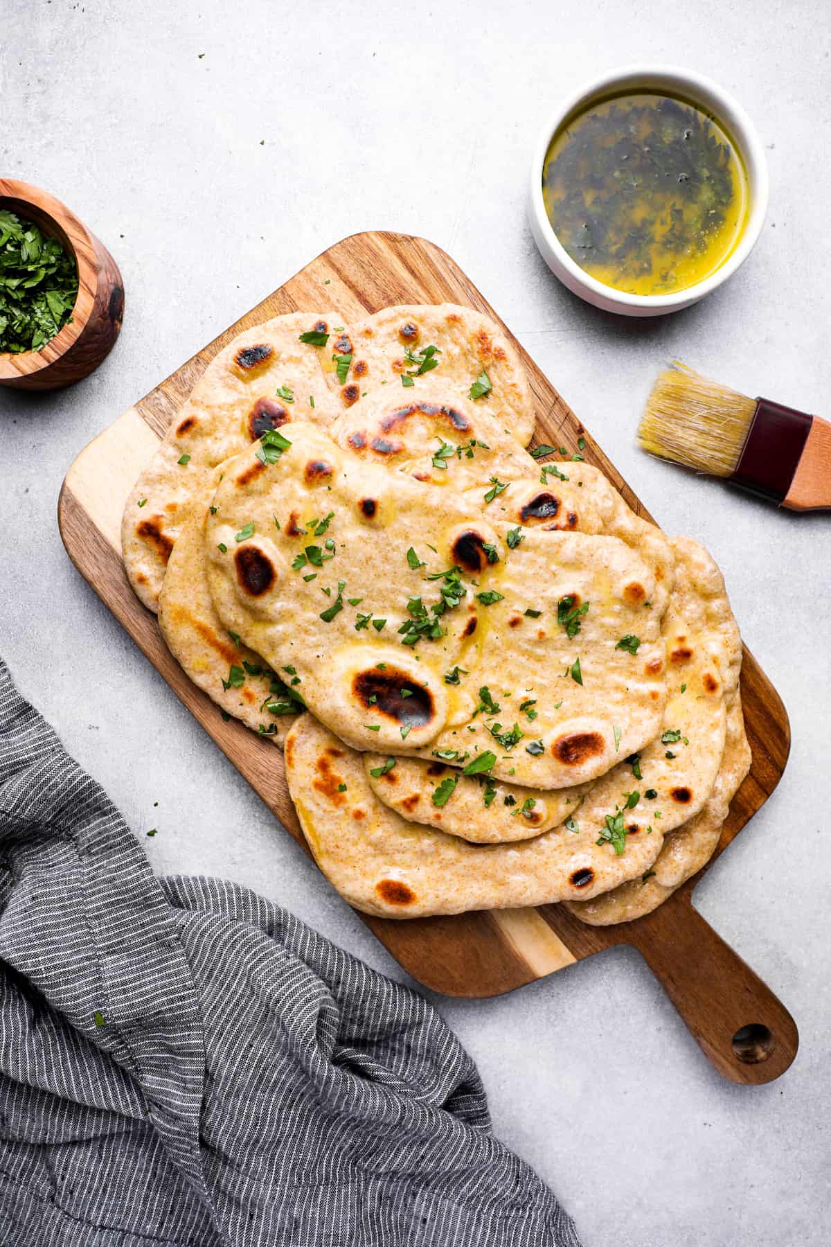 a pile of homemade naan bread on a cutting board